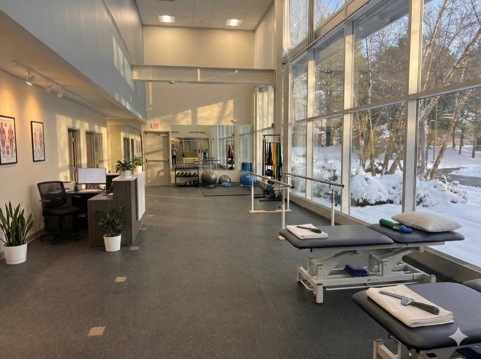 The Lymphedema-Oncology Rehab Center clinic — a bright, light-filled therapy space with treatment tables, parallel bars, and rehabilitation equipment
